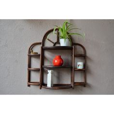 a wooden shelf with two shelves and a potted plant on top, against a gray wall