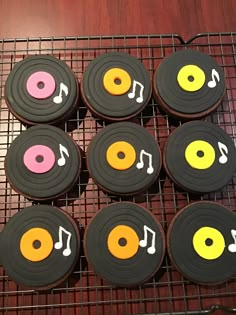 cupcakes decorated with music themed icing are on a cooling rack, ready to be eaten