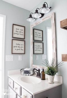 a bathroom with a sink, mirror and pictures on the wall above it's vanity