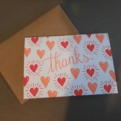 a thank card with hearts and the words thanks written in cursive writing on it