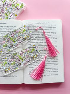 an open book with tassels on top of it