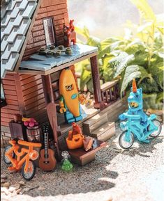 there is a small toy house with toys in front of it and an orange bike next to it