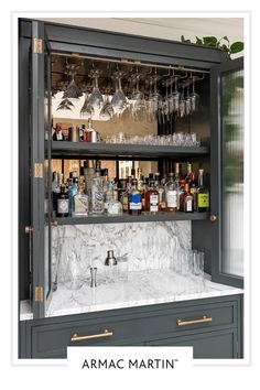 a bar with wine glasses and liquor bottles on the top shelf in front of it