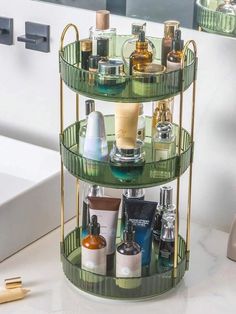 three tiered shelf with bottles and cosmetics on it in the middle of a bathroom