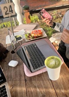 a person sitting at a table with a laptop and cell phone in front of them