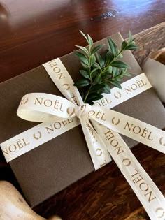 a present wrapped in brown paper and tied with a ribbon that says noel & noel