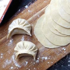 some dumplings are sitting on a cutting board and ready to go into the oven