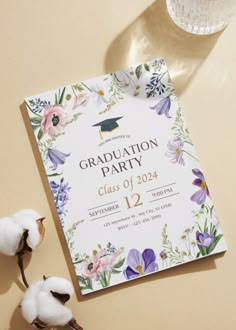 a graduation party card with flowers and cotton floss on the table next to it