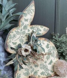 a stuffed animal sitting on top of a table next to some plants and other decorations