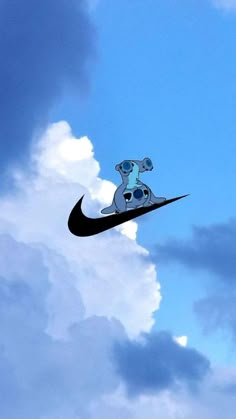 a black and white nike logo is flying through the air with clouds in the background