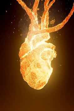 an orange and yellow heart shaped object floating in the air with fire coming out of it