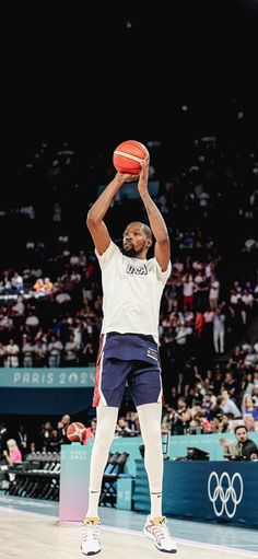 a man holding a basketball up in the air