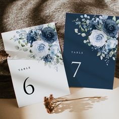 two cards with blue flowers on them are next to each other and the table number is 7