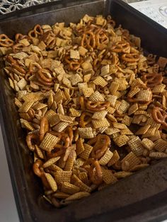 a baking pan filled with cheetos and pretzels