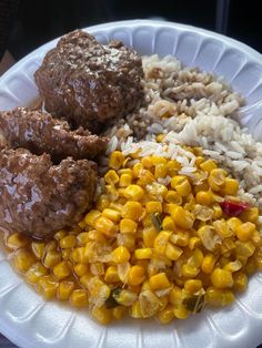 a white plate topped with meatballs, rice and corn