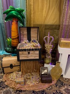 a table topped with boxes and vases on top of a carpeted floor next to curtains