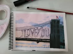 an open notebook with the word new york written on it next to a marker and pen