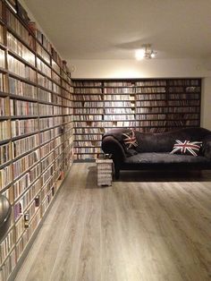 a room filled with lots of books and a couch in front of a book shelf