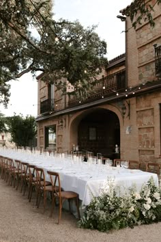 a long table is set up outside in front of an old building