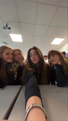 four girls are posing for the camera with their arms around each other