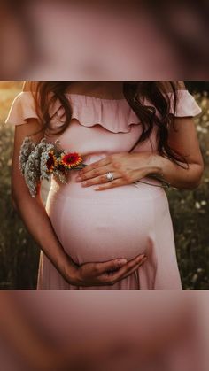 a pregnant woman holding flowers in her belly