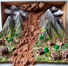 an open cardboard box with a mountain scene in the middle and trees on the other side