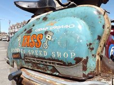 an old rusted motor scooter is parked on the street