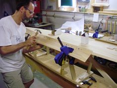 a man working with wood in a workshop