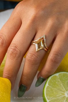 a woman's hand with a ring on her finger and lemon slices around her