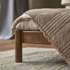 a bed with a wooden headboard and foot board on top of carpeted floor