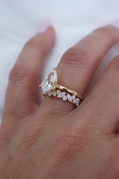 a woman's hand with a gold and diamond ring on top of her finger