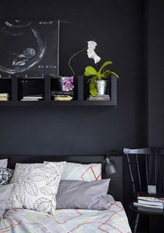 a bed room with a neatly made bed next to a book shelf filled with books