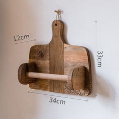 a wooden cutting board mounted to the side of a wall with a rolling pin on it