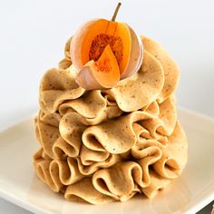 a stack of tortilla chips with an orange slice on top, sitting on a white plate