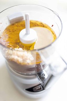 a blender filled with food on top of a white counter