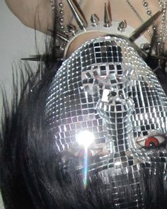 a woman with shiny silver hair has her head covered in disco balls and mirrors on top of her head