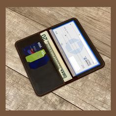 an open wallet with a credit card and id in it on a wooden table top