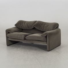 a gray couch sitting on top of a white floor