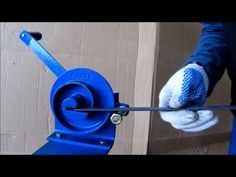 a person with gloves on holding onto a blue machine