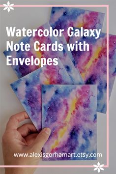 four watercolor galaxy note cards with envelopes in the middle and text overlay that reads, watercolor galaxy note cards with envelopes