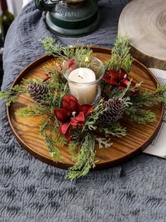 a candle and some pine cones on a tray