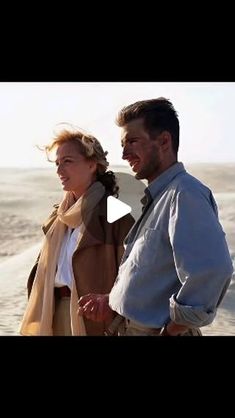 a man and woman walking on the beach