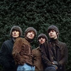 the beatles posing for a photo in front of some bushes