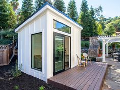 a small white house sitting on top of a wooden deck