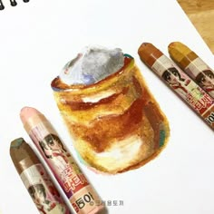 some crayons are sitting on top of a piece of paper with an image of a pancake