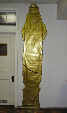 a large golden statue in front of a white door