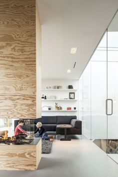 two people sitting on the floor in front of a fireplace