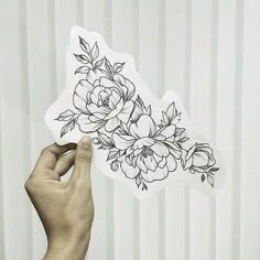 a person holding up a sticker with flowers on it