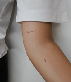 a woman's arm with a small tattoo on the left side of her arm