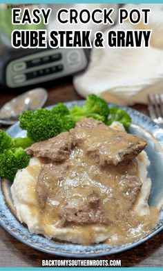 a blue plate topped with meat and gravy next to broccoli